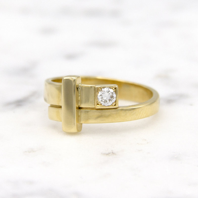 Mondria damesring in 14 karaat geelgoud met diamant, op marmer