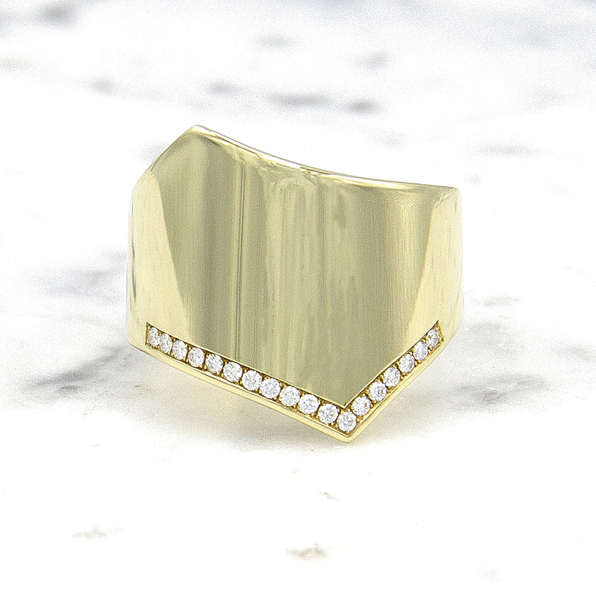 Wave damesring in 14 karaat geelgoud met diamanten, op marmer